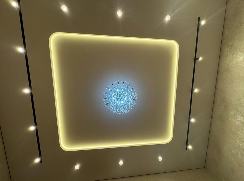 Глянцевый натяжной потолок с люстрой и LED-подсветкой по периметру